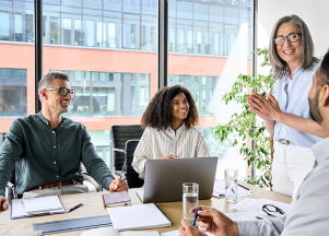 Group of four office workers collaborating in a conference room. 