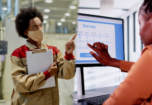 Data collector wearing a mask in door and data collector answering survey online. 