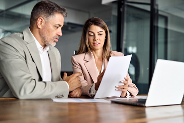Female compliance officer showing a document to a male colleague