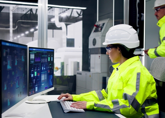 Power plant operator using computer at control station.  