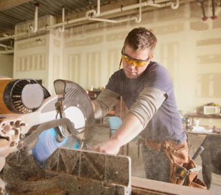Man sawing lumber in a woodshop