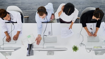 Stock image of staff assisting customers on the phone and computer